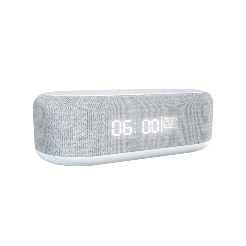 Product in a modern bedroom setting with ambient night light glowing, phone charging, and alarm clock displaying time and calendar.